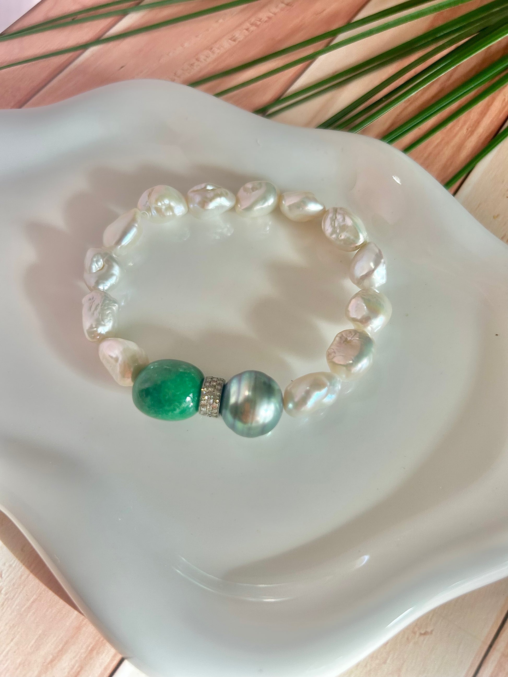 13 Fresh water pearls accented with a large ,smooth emerald stone and a large , natural Tahitian pearl. Separated by a gorgeous pave diamond roundlet.